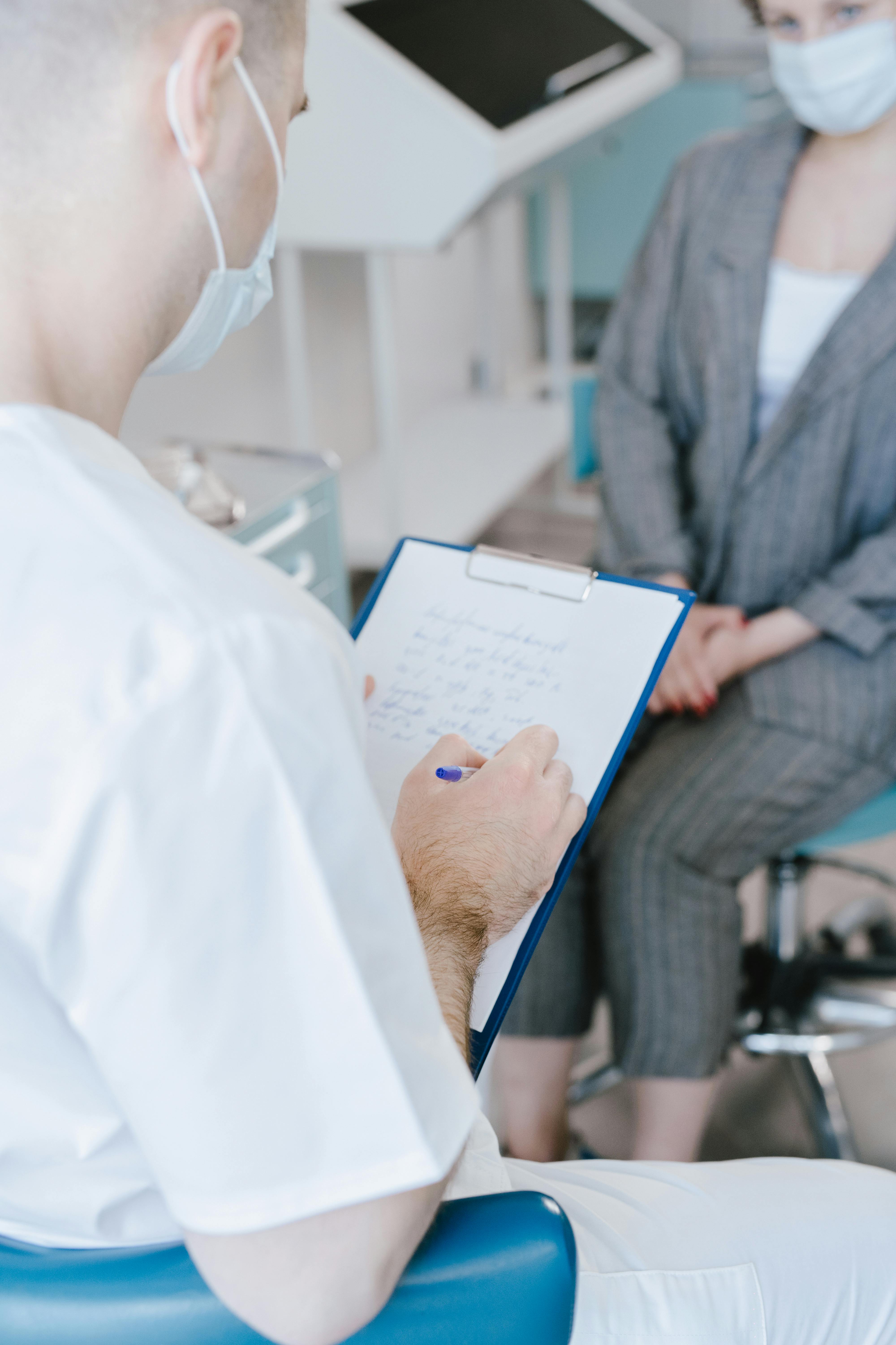 Ein Krankenpfleger spricht mit einer alten Dame und macht Notizen in einer angenehmen Umgebung